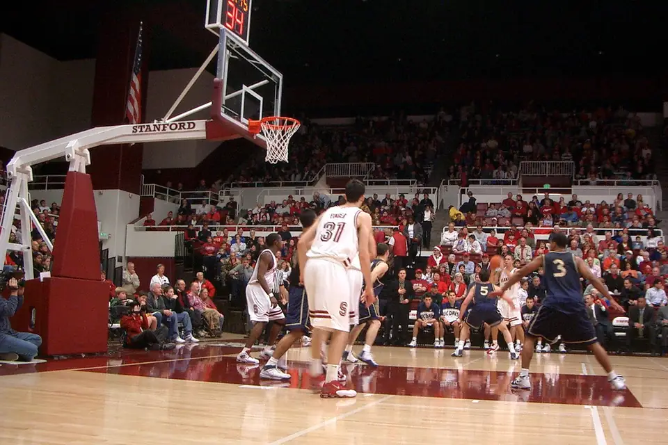 Players contesting a rebound in a crowded basketball arena
