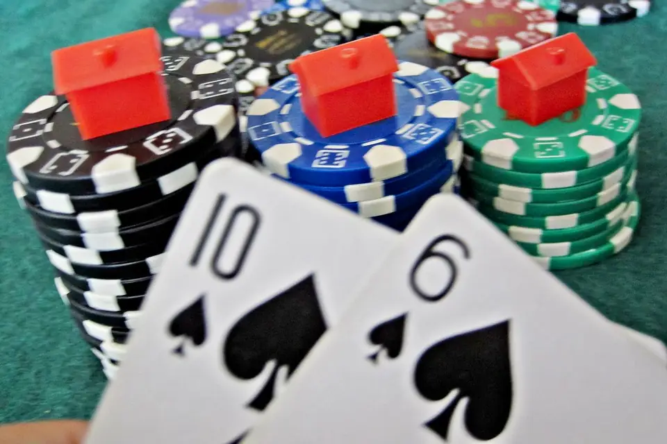 Stacks of casino chips beside a ten and six of spades