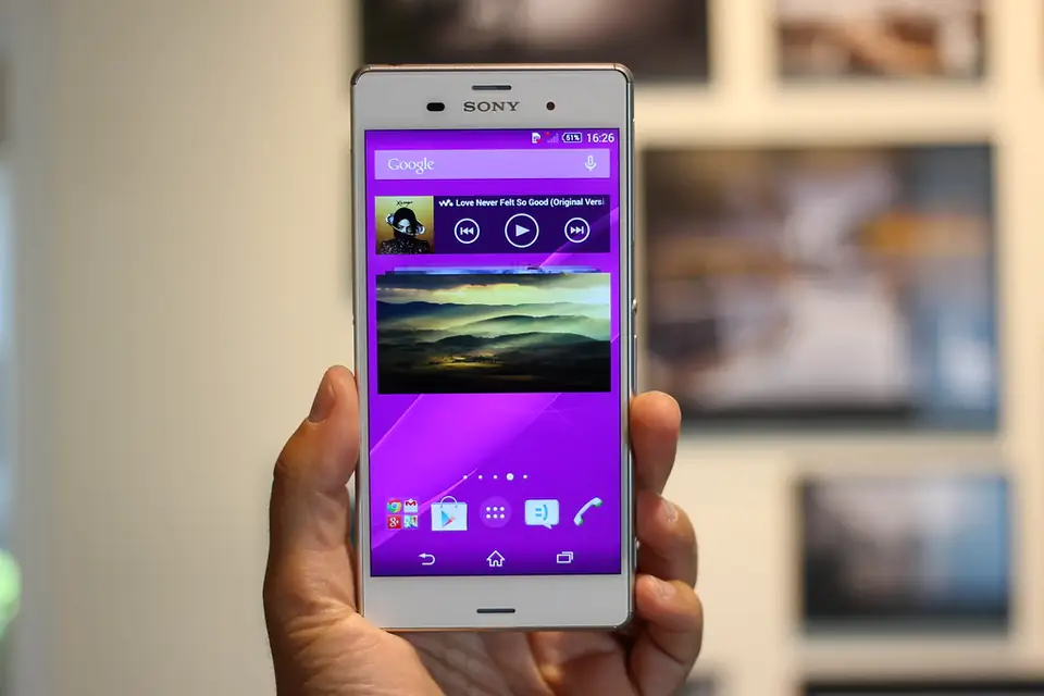 Smartphone held in one hand showing an app screen